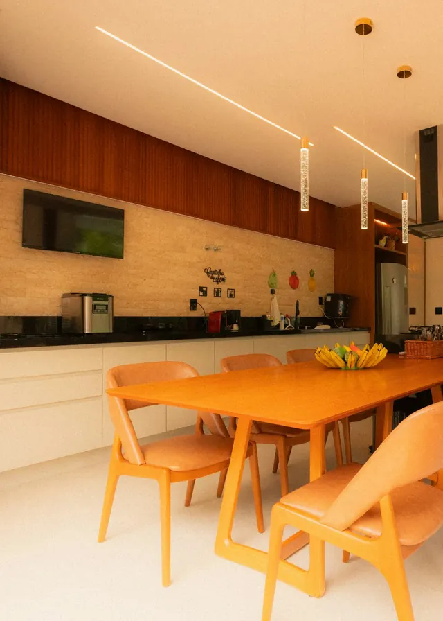 Cocina y comedor compartidos con una mesa larga de madera