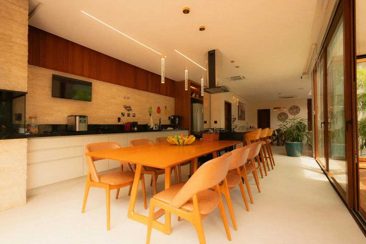 Cocina-comedor compartida, con una mesa larga de madera y cristaleras hacia el exterior.