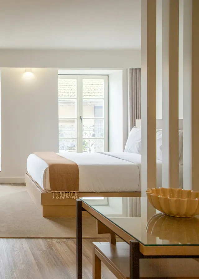 Habitación de hotel luminosa en tonos crema y madera